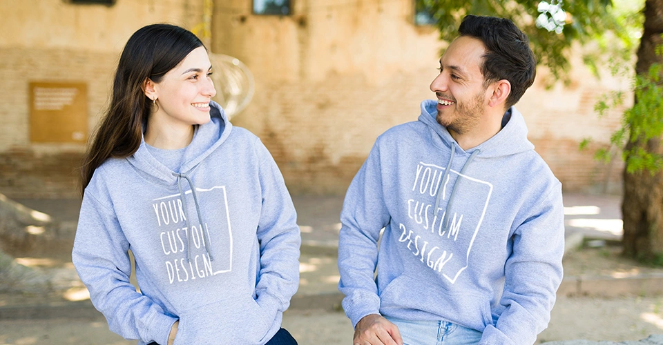 Fröhliches Paar mit individuellen College Hoodies