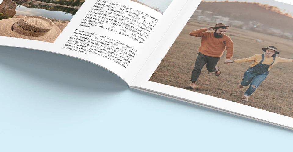 Fotoheft mit Rückstichheftung in Detailaufnahme auf blauem Hintergrund