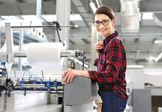 Employee in production hall smiling at the camera